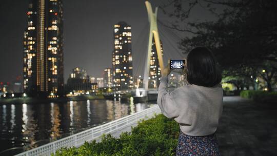 女人在拍摄城市的大楼