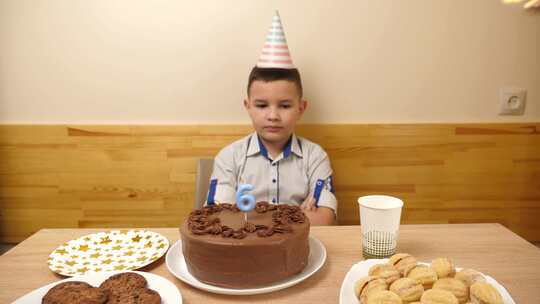 05sm.男孩坐在一张放着节日蛋糕的桌子