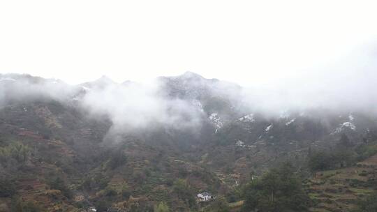 皖南晨雾中的乡村和雪山