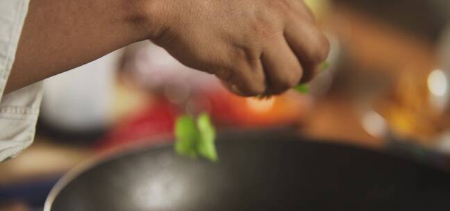 厨师往锅中撒蔬菜的慢动作