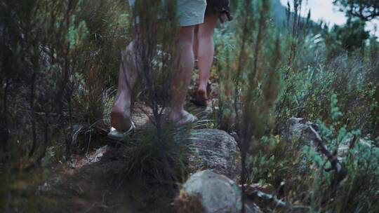 夫妇穿着拖鞋走在山林里腿部特写