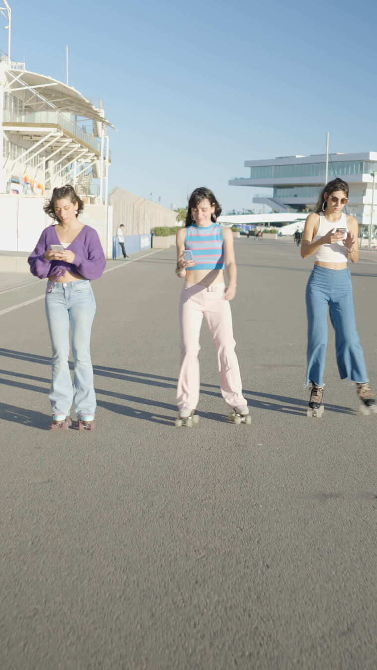 三个女孩使用手机滑旱冰时的额叶平滑