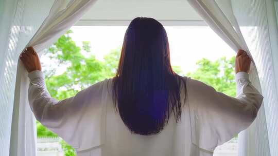 女子拉开窗帘迎接朝阳清晨柔和光线阳光照进