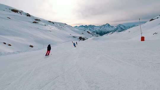 人们在以美丽雪山为背景的斜坡上滑雪