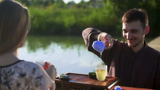 朋友们在森林湖中的木桥上喝凉茶