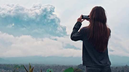 给火山爆发拍照的女人