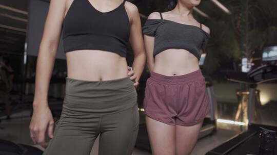 两个女性朋友健身房镜子前摆姿势