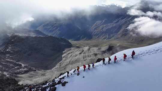 航拍攀登横断山脉乌库楚雪山山脊上的登山者