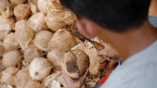 男人砍椰子壳纤维的特写视频素材模板下载