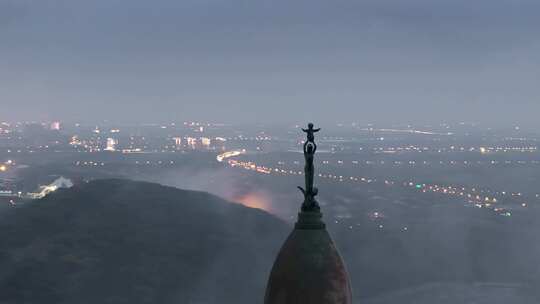 航拍夜晚雾气中的教堂圣母像雕塑