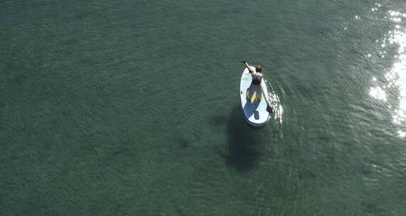 湖中桨板上练瑜伽的女人
