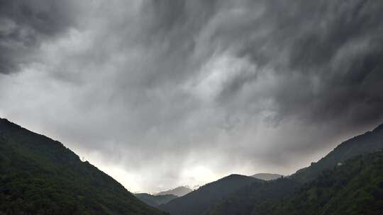 厚厚的黑色云层覆盖着森林山脉之间的山谷
