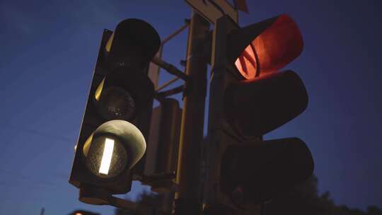 黄昏时的红绿灯，发出发光的红色信号和一盏