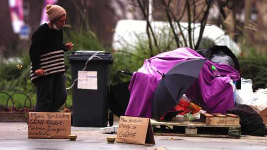 一个女人打着紫色雨伞走在街上