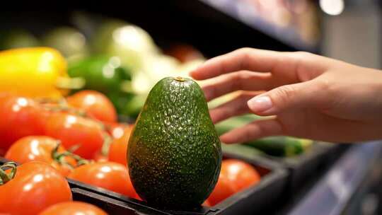 手选牛油果于蔬菜摊