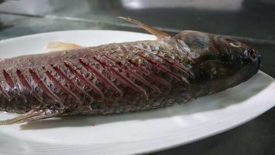 一只被改过花刀的鱼躺在盘子里
