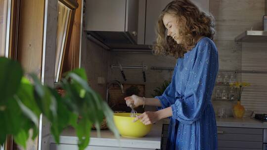 女人用搅拌器在碗里搅拌面糊