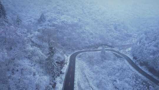 4K冬季下雪山上的道路航拍视频