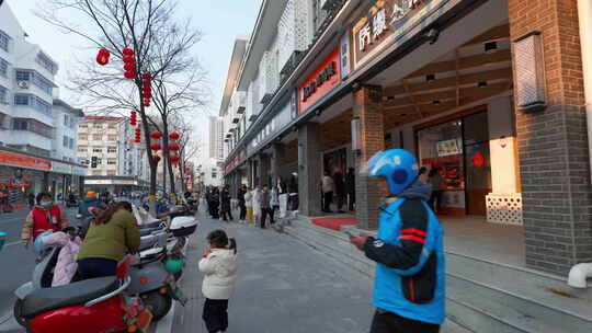 泰州街道上有快递员和路人的城市街景