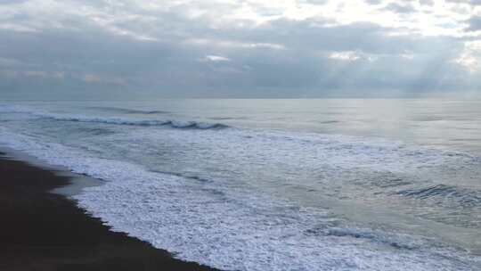 阴天海浪拍打沙滩的海边景象