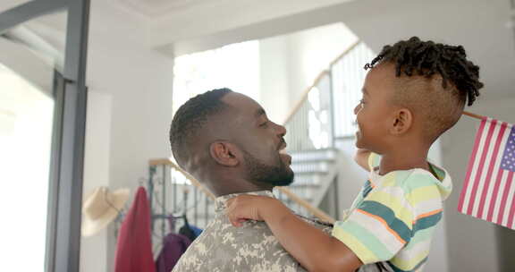 穿着军装的非裔美国父亲在家里的家庭环境中
