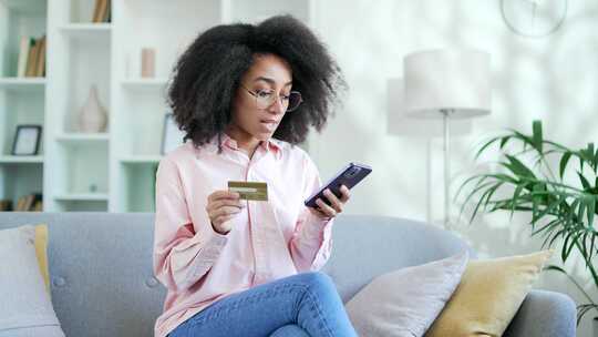 震惊不安年轻的非裔美国女性发现输入信用卡