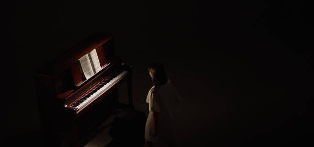 聚光灯下美女弹奏钢琴