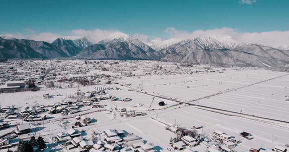 雪山山脚下大雪覆盖的村落天际线景观