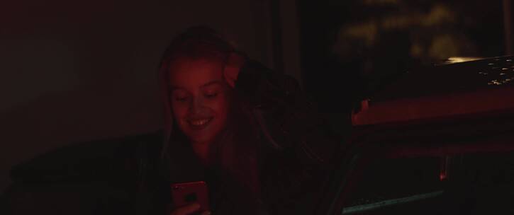 昏暗中使用手机的女孩