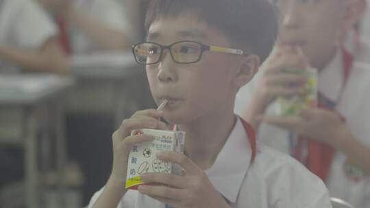 红领巾小学生在学校分牛奶吃下午茶喝学生奶