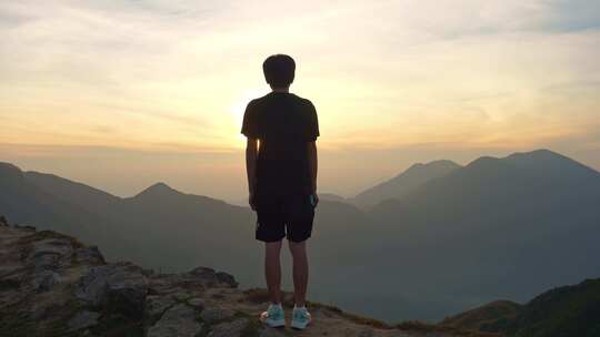 男子山顶赏日出远景