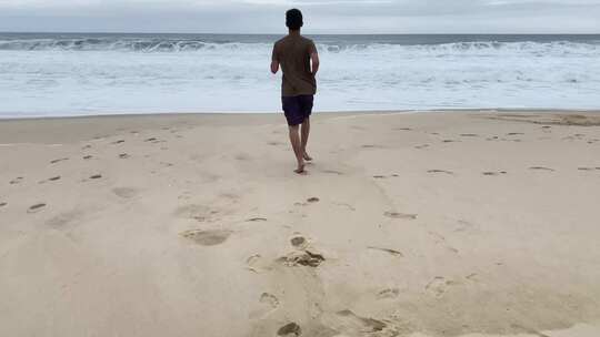 男子赤脚跑向海边