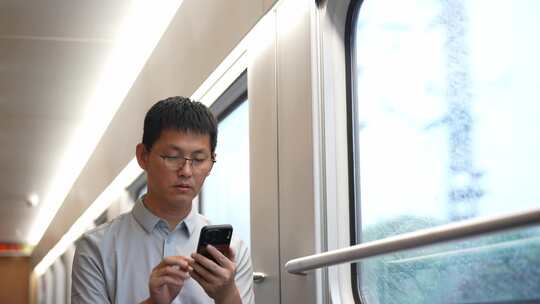 男子在卧铺火车过道上使用手机