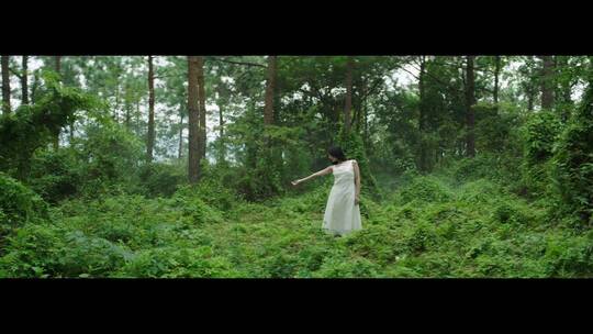 白色连衣裙女子在森林里跳舞