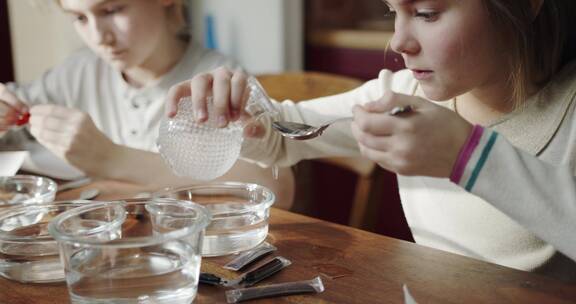 女孩在桌子上制作液体溶液