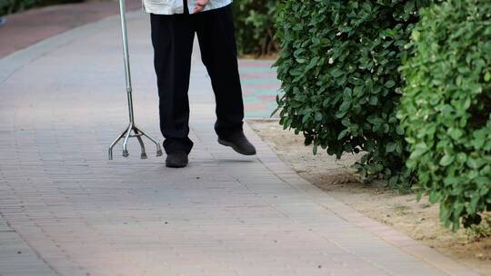 步履蹒跚拄拐杖的患病老人