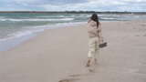 暴风雨中海滩上的年轻女人高清在线视频素材下载