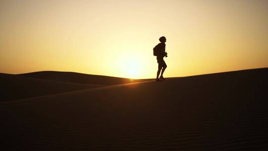 游客在黄昏的沙漠上行走