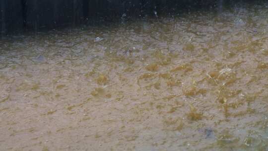 浑浊积水水面雨滴飞溅