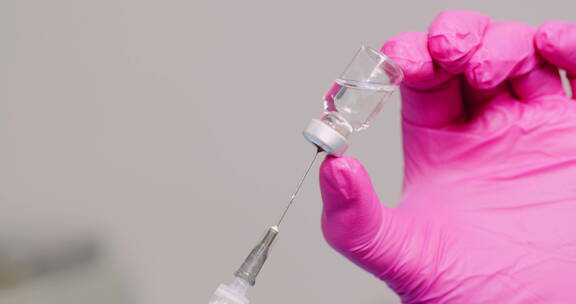 手握注射器和疫苗的特写