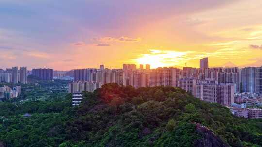 惠州大亚湾夕阳下的城市高楼与山林景观