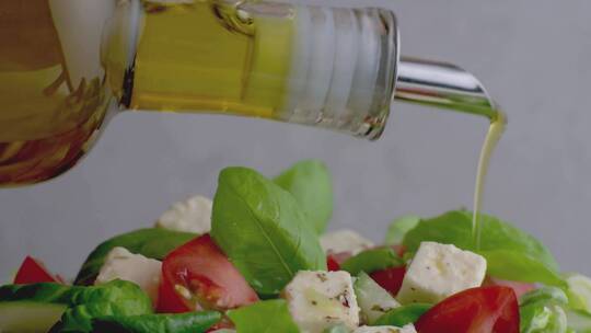 在新鲜健康沙拉上淋上橄榄油视频素材模板下载