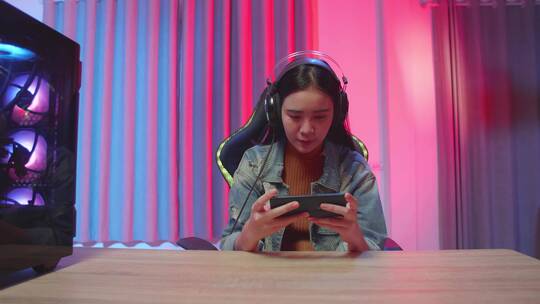 女孩戴着耳机玩手游视频素材模板下载