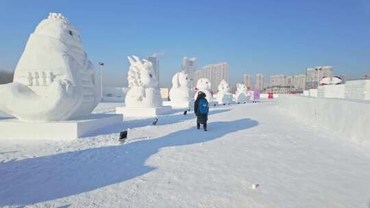 十二生肖雪人雪地上有人背着包走过雪雕群像