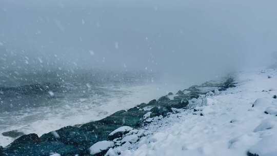 海边雪景与海浪拍打岩石