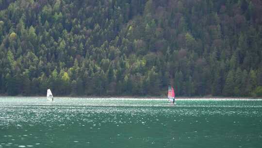 在山上的阿琴湖上滑浪风帆。奥地利阿尔卑斯山的水上运动。视频素材模板下载