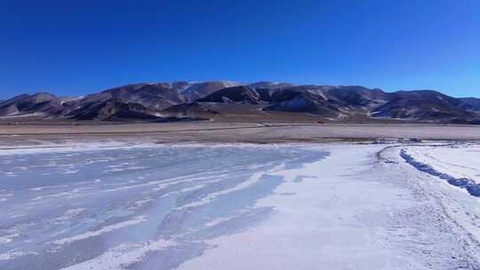 航拍新疆冬季赛里木湖冰封湖面雪山冰湖积雪