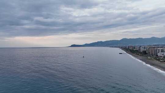 日落时分，帆船停泊在海湾中，水清澈碧绿