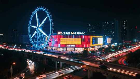 夜景中摩天轮旁的购物中心
