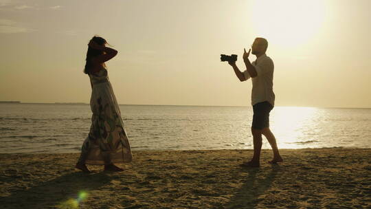 日落海边摄影师给女孩拍照视频素材模板下载